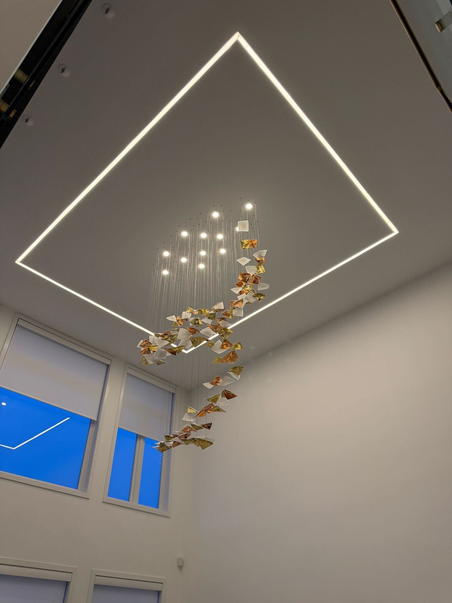 Double-height foyer with rectangular LED ceiling frame and decorative chandelier