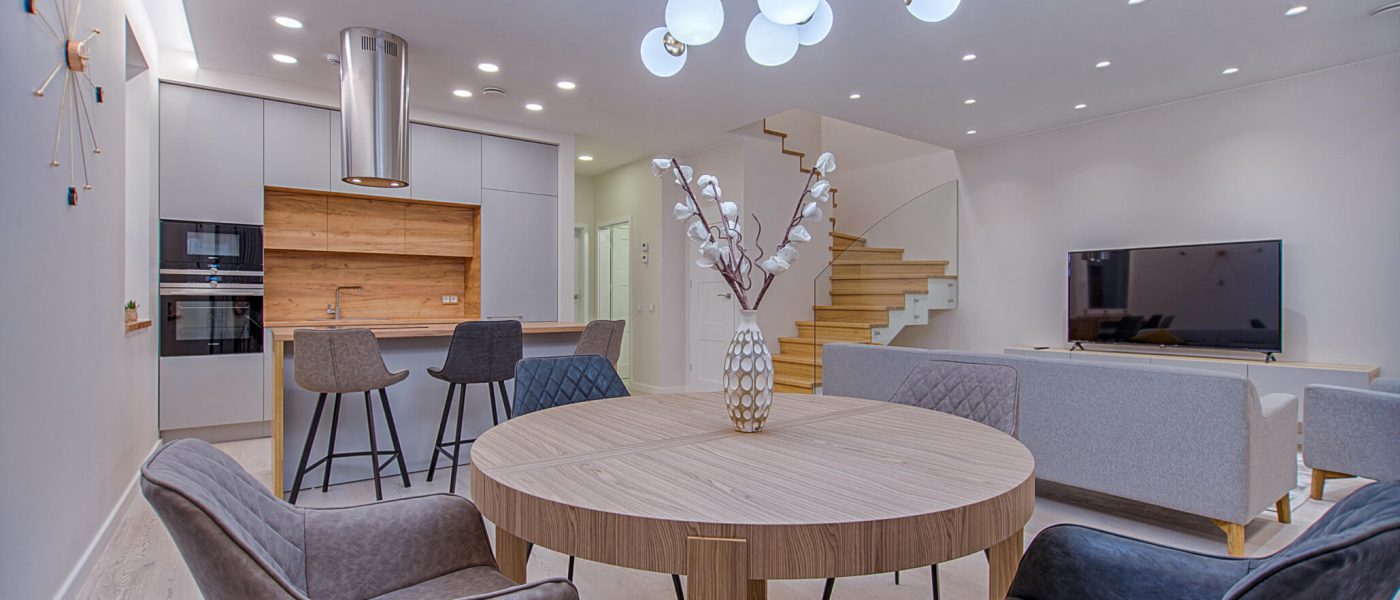 Open-plan home with pot lighting and a range hood installed in the kitchen